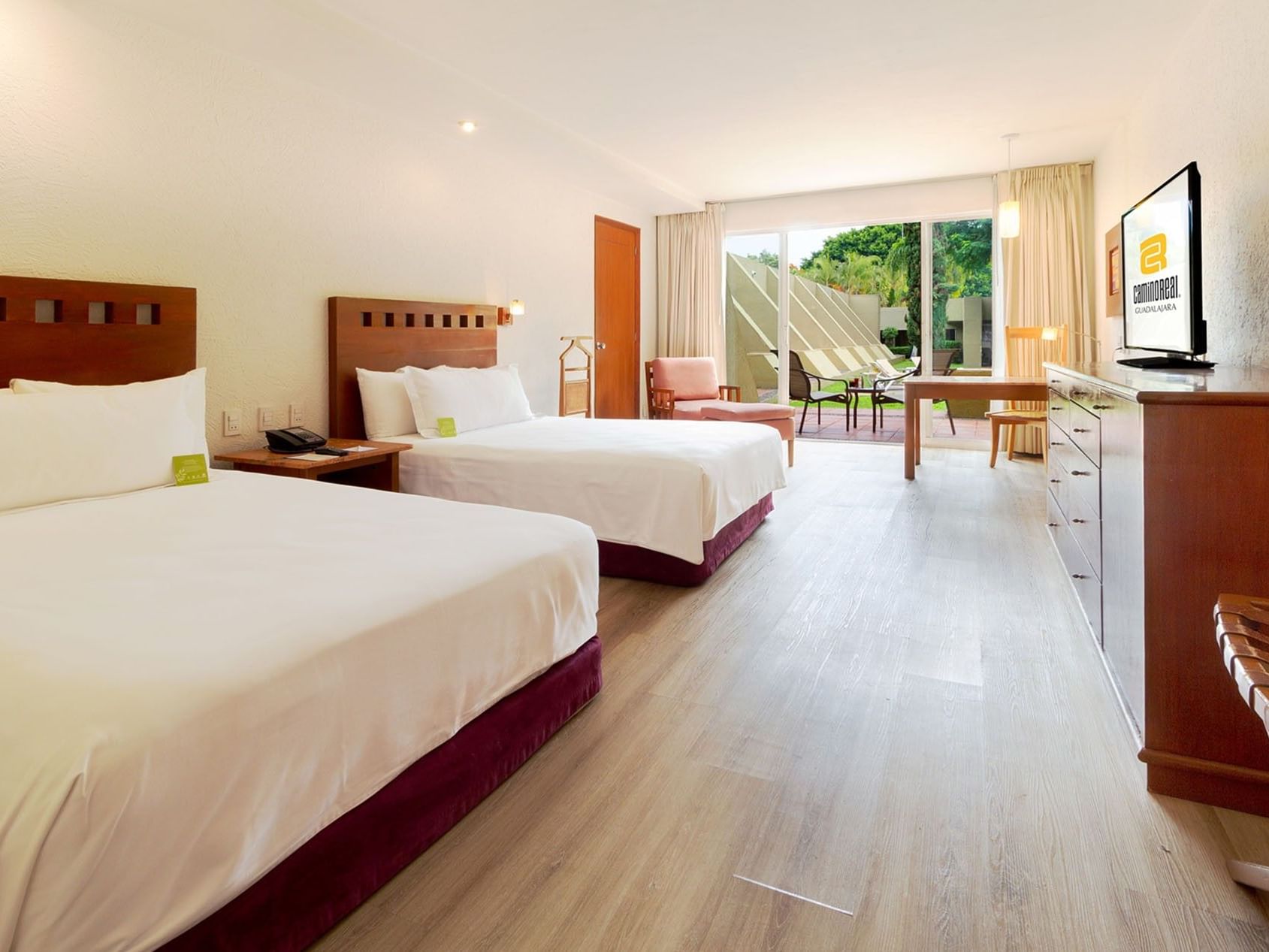 2 Double Camino Real Club Executive at Camino Real Guadalajara with two double beds, a wooden desk, and a patio entrance
