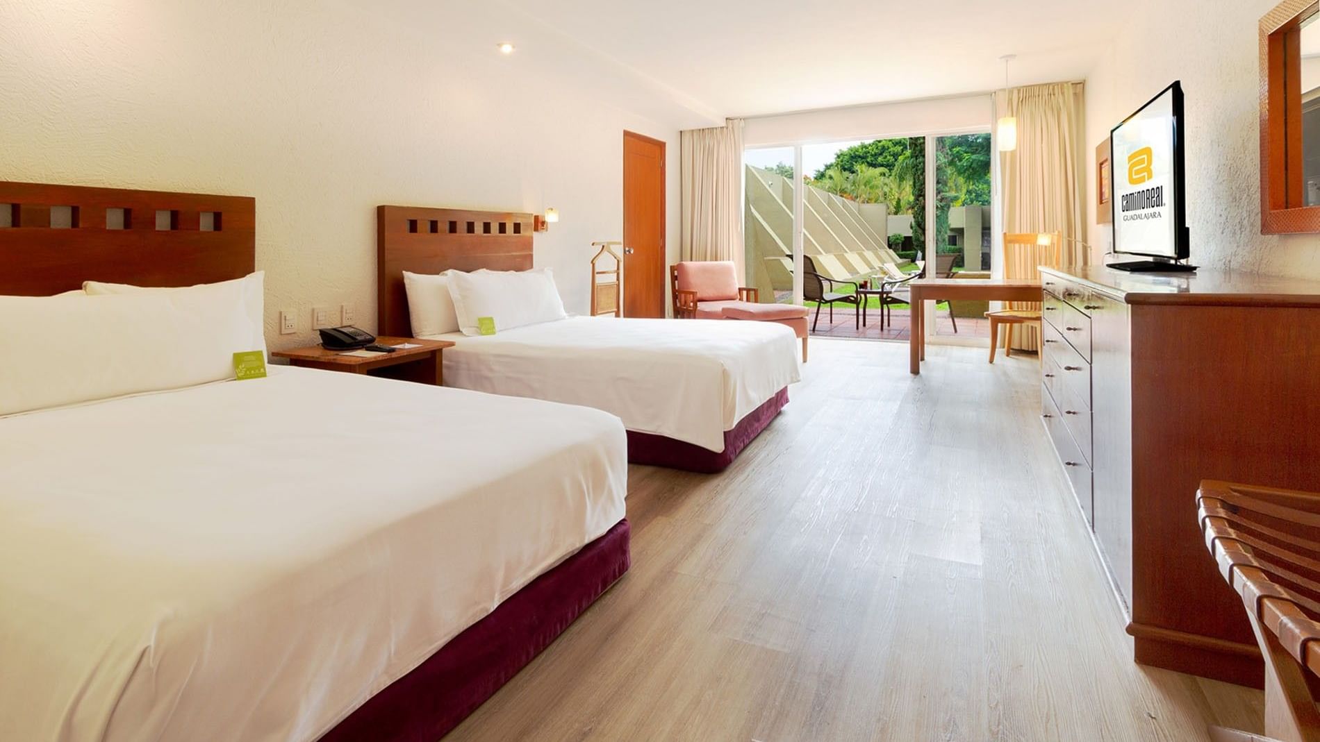 2 Double Camino Real Club Executive at Camino Real Guadalajara with two double beds, a wooden desk, and a patio entrance