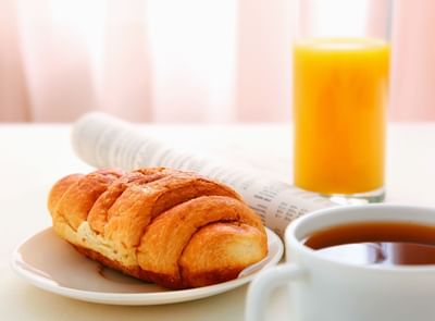 Photo of a croissant, orange juice, and coffee
