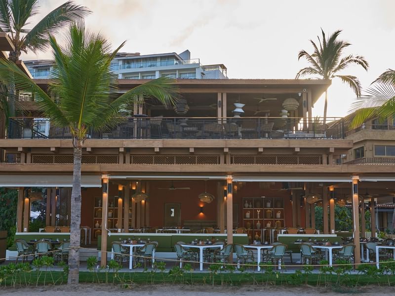 Modern beachfront restaurant at Fiesta Americana with multiple levels, palm trees, and outdoor dining areas
