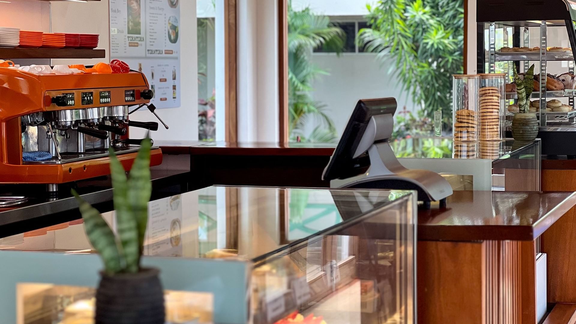 Coffee shop counter with an espresso machine and display case at Tokatoka Resort - Fiji International Airport in Nadi