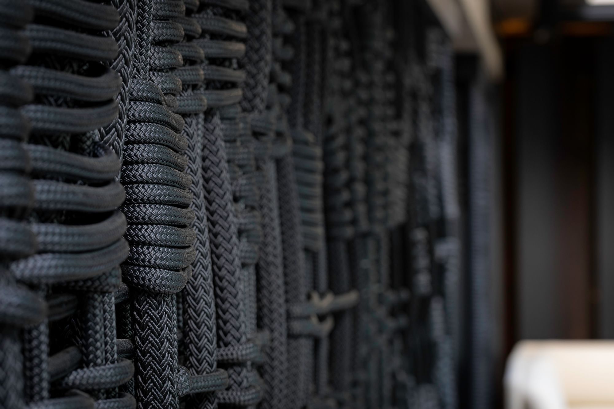 Close-up of intricate dark woven wall decor, adding texture and depth to 8 at The Londoner interior at The Londoner Hotel