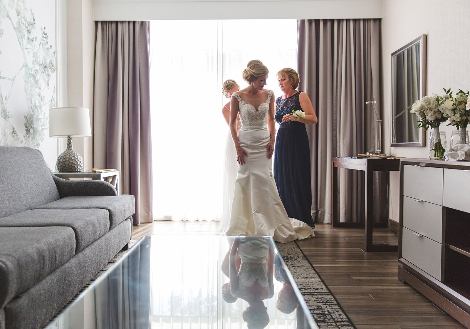Two ladies helping a bride with her dress at The Grove Hotel