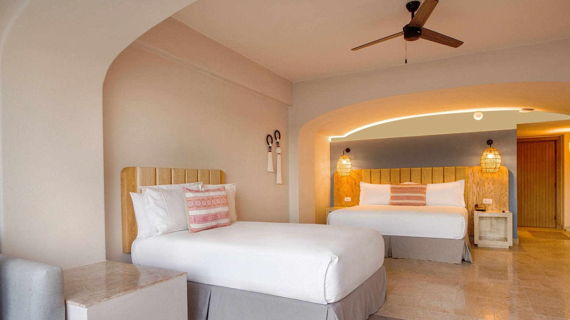 Extra King Bed and Double Bed Deluxe Superior Room with warm lighting and wooden accents at Camino Real Acapulco Diamante