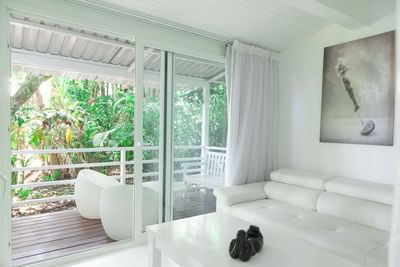 Bright living space with modern furniture and garden views through balcony doors at Le Cameleon Boutique Hotel