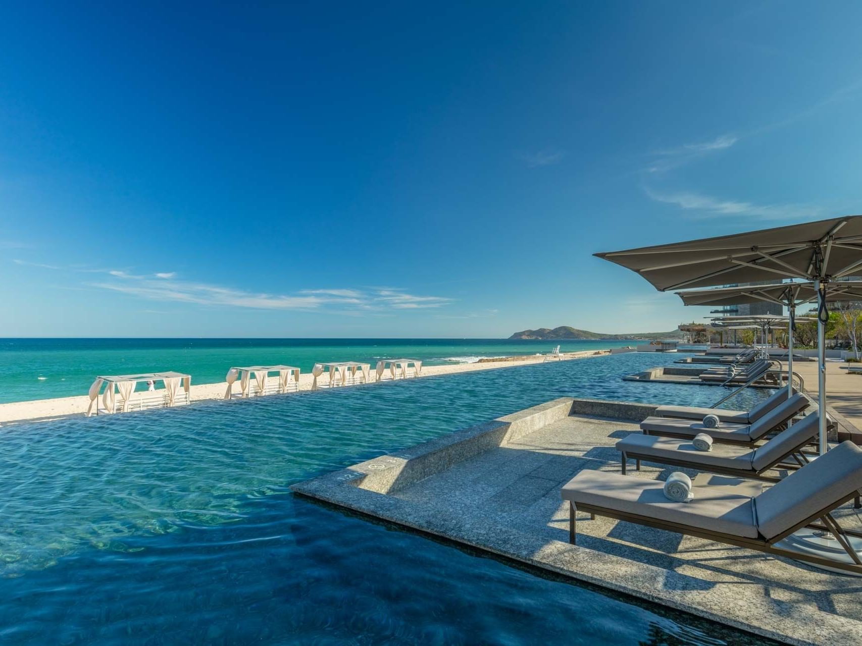Pool with lounge chairs by the sea at The Club at Solaz