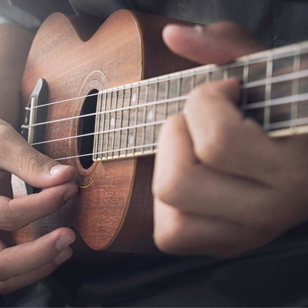 Close-up of a man playing a Ukulele at Waikiki Resort Hotel by Sono