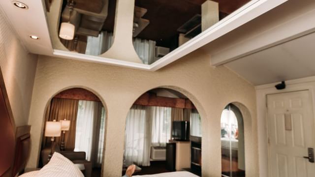 Couple relaxing on the bed with a mirror ceiling at Cove Pocono Resorts