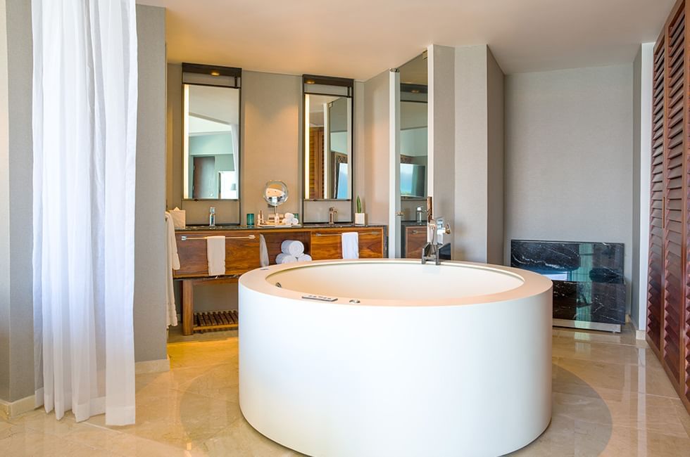 Bathroom with a round bathtub, & wooden vanity in suite at Live Aqua Resorts and Residence Club