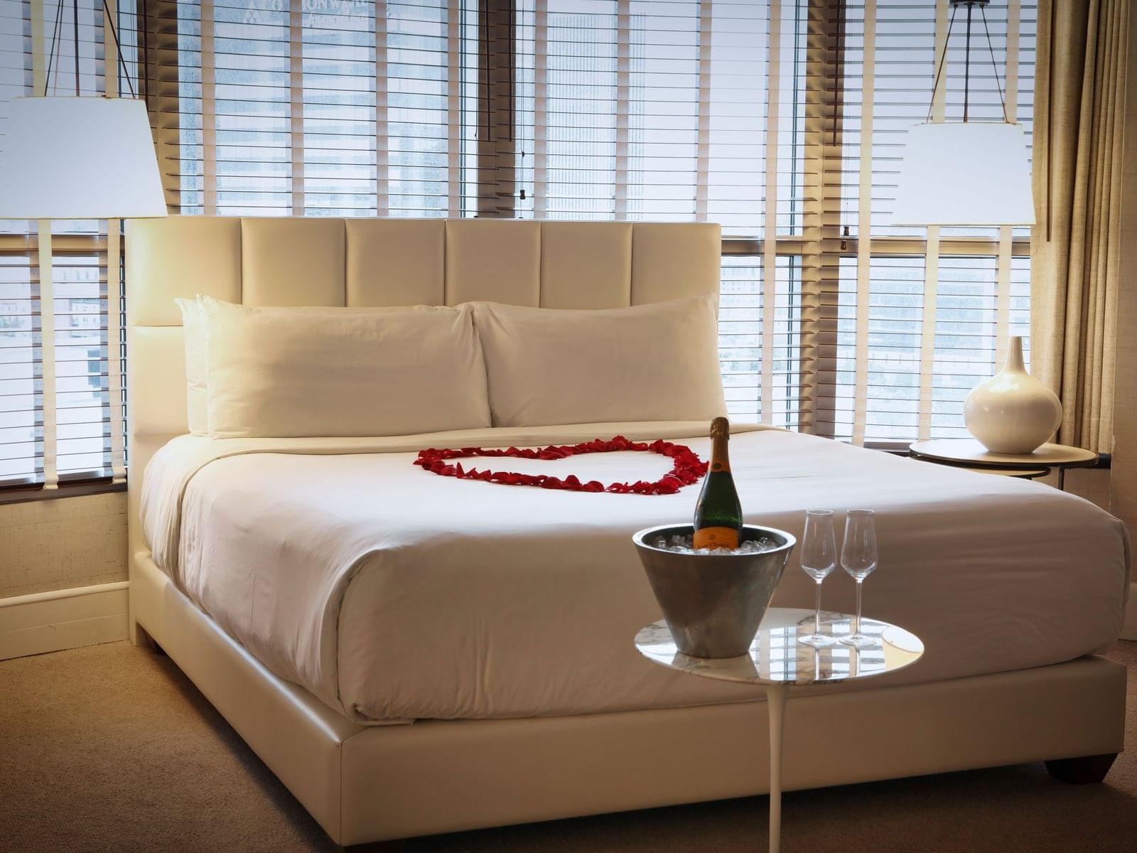 Champaign served on a bucket of ice by a bed with rose petals at Hotel Republic San Diego