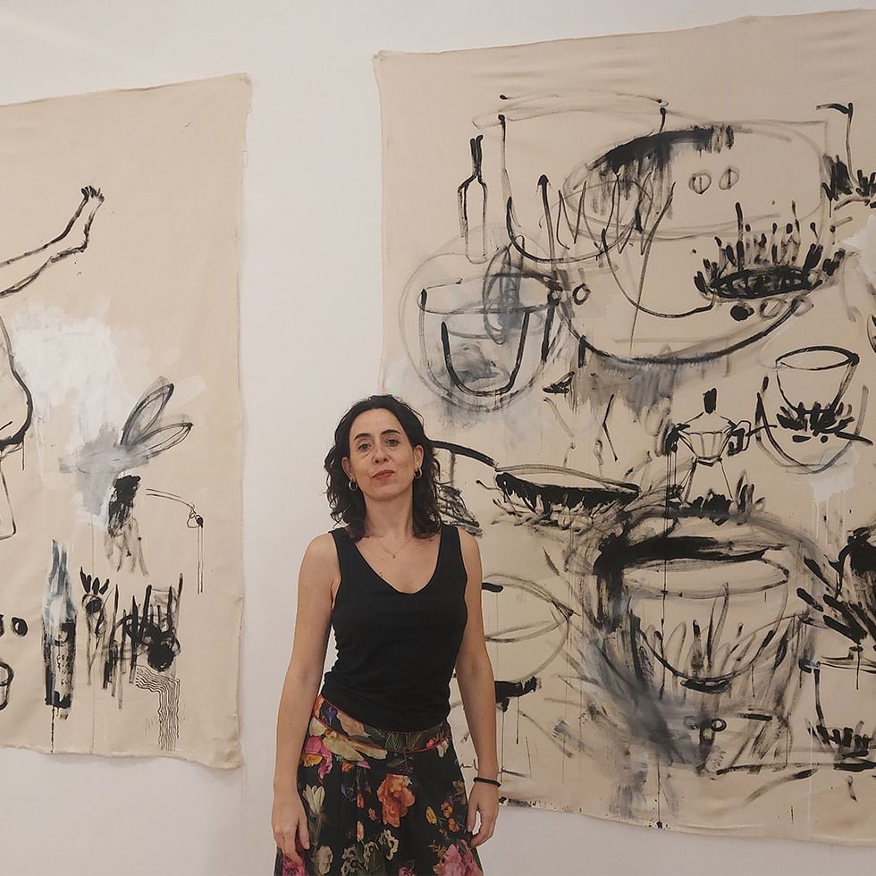 Woman standing before abstract monochrome artwork on canvas at Falkensteiner Resort Capo Boi