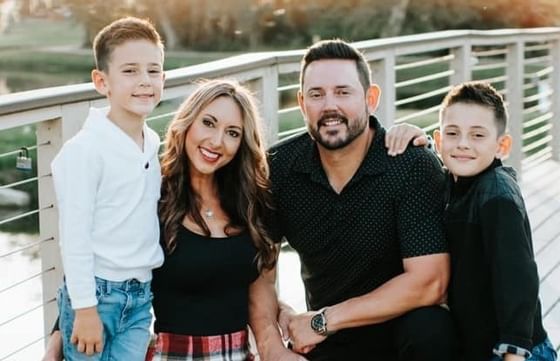 Family of four smiling on a bridge at Vista Cay Resort By Millenium