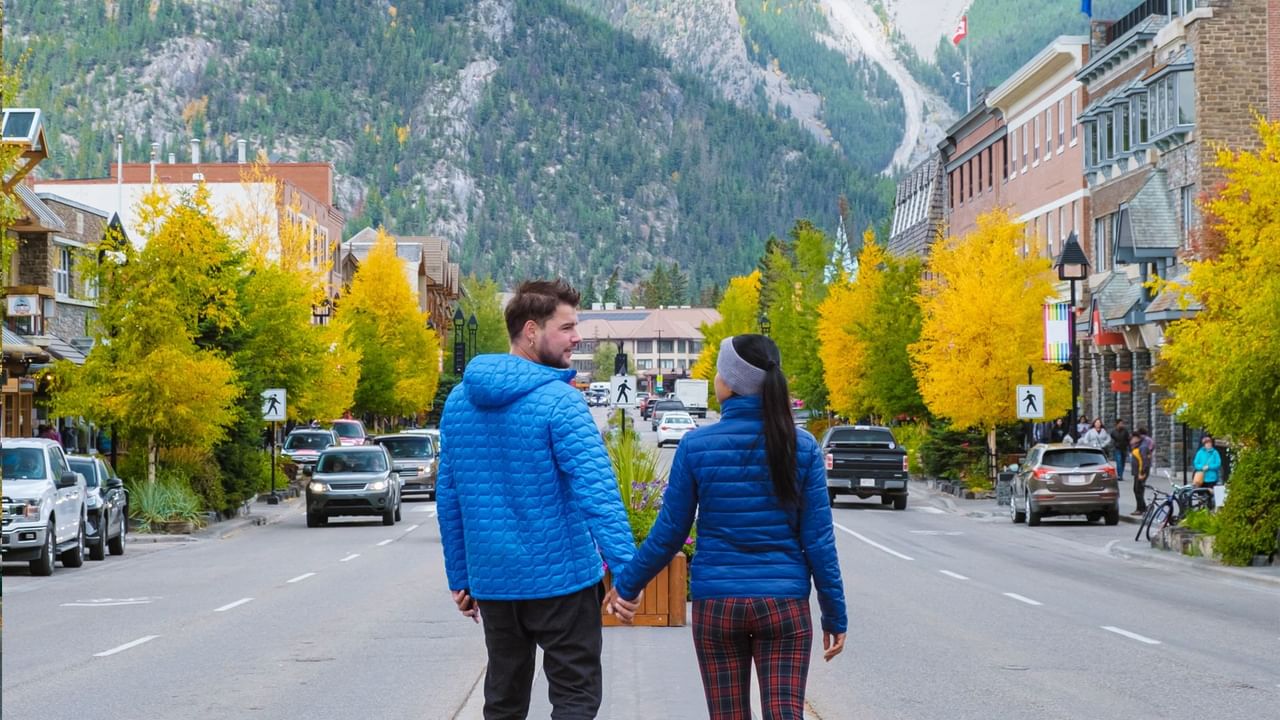 Two people walk through Canmore on their way to a Canmore tour.
