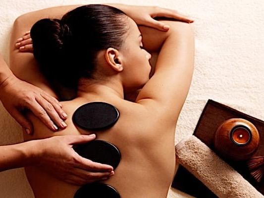 Hot stones on a lady in the Spa at Casa Colonial Beach and Spa