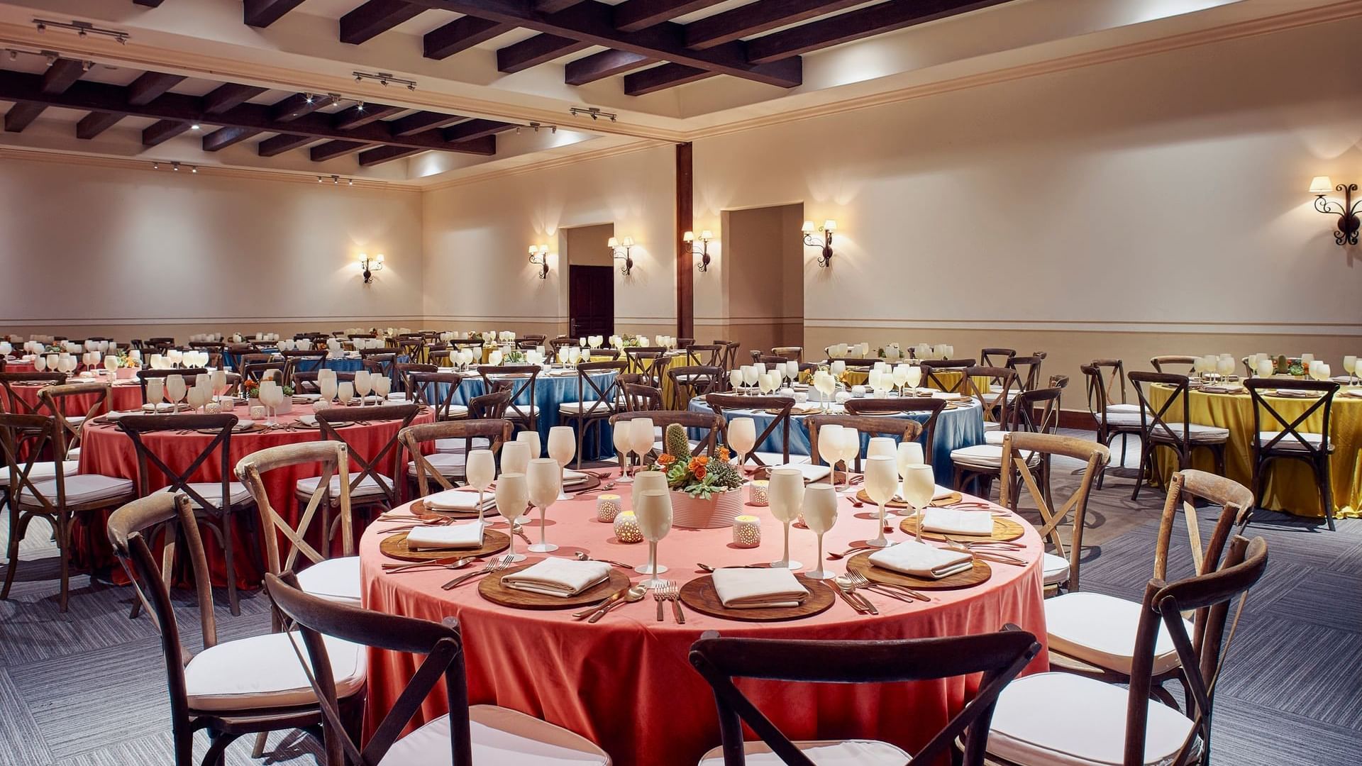 Elegantly set round tables with tableware and wine glasses in Arcos 3 event room at Hacienda Del Mar Los Cabos in Cabo San Lucas.