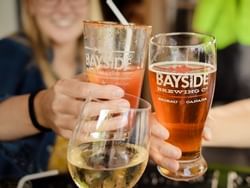 Close-up of beer toasting at Bayside Brewing near Retro Suites Hotel