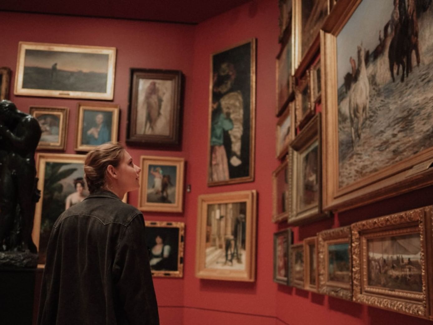 A woman looking at paintings in New Orleans Museum of Art