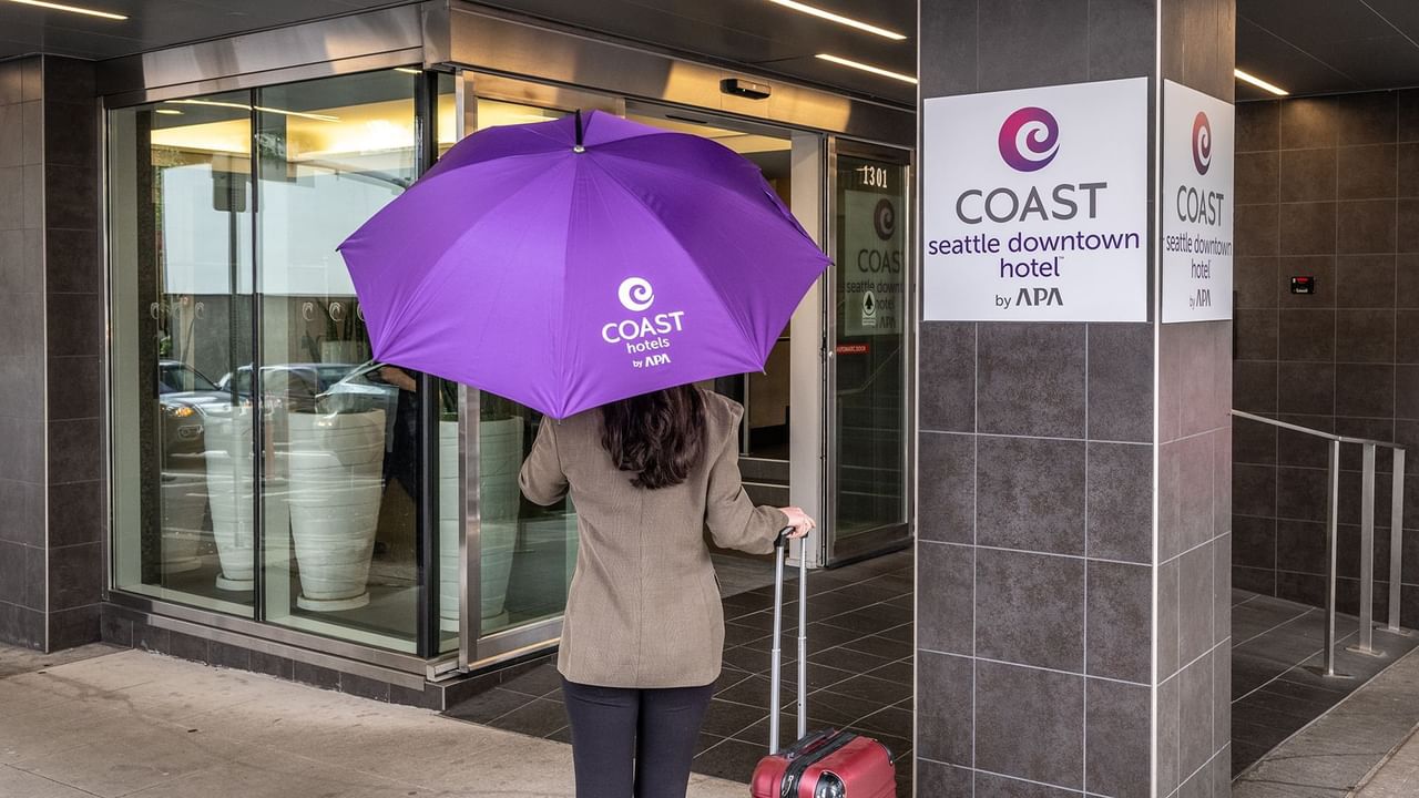 Women walking with purple Coast Hotel umbrella into their downtown Seattle hotel