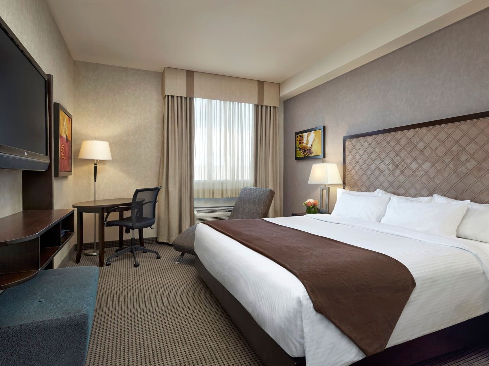 Platinum One King Bed Room interior with work desk & TV at Acclaim Hotel Calgary