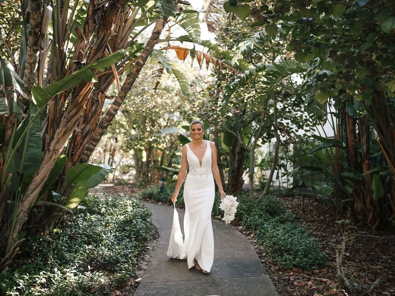 Bride posing in the tropical wedding garden pathway at Pullman Magenta Shores