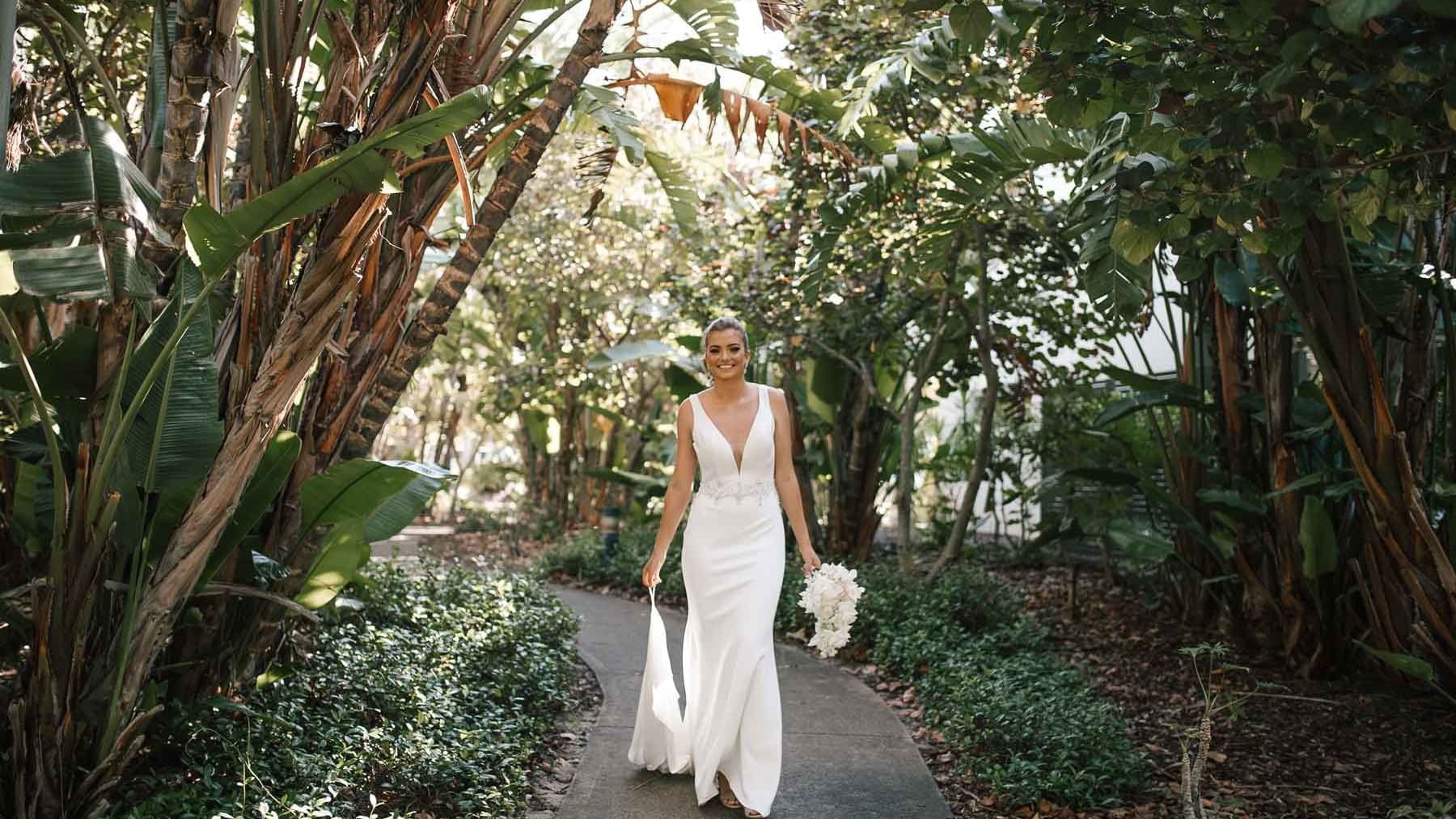 Bride posing in the tropical wedding garden pathway at Pullman Magenta Shores