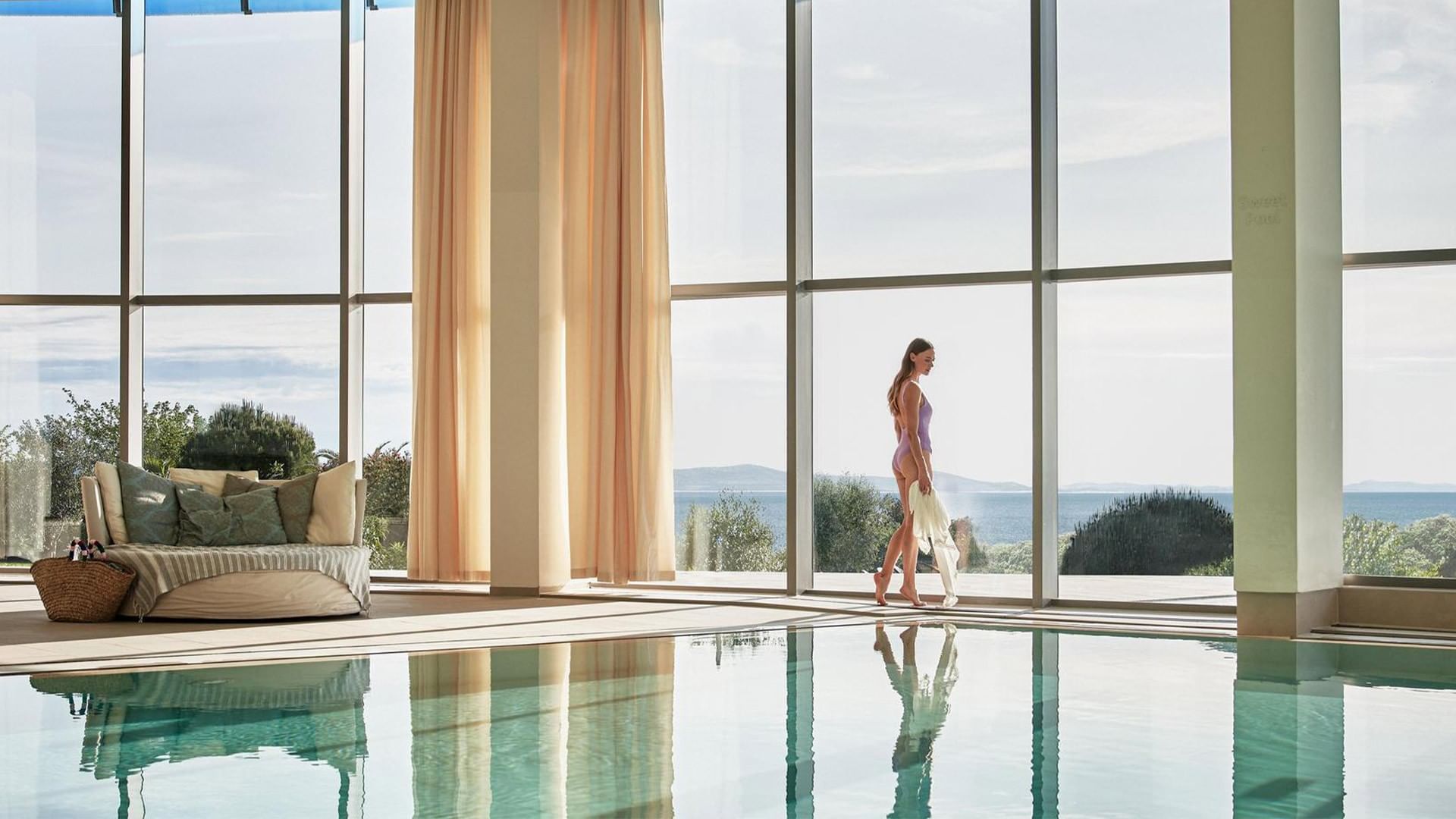 Frau am Pool mit Meerblick und eleganter Lounge bei Falkensteiner Resort Punta Skala