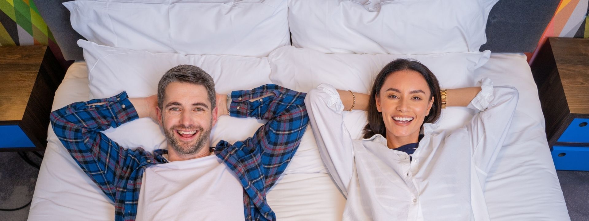 A couple lying down on a bed at Village Hotels