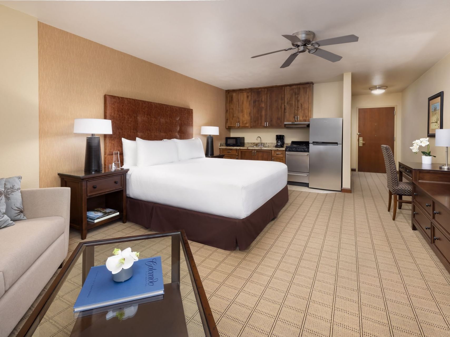 Elevation Hotel ADA King Room with a bed, couch, coffee table, refrigerator, and a kitchen area.