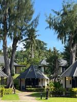 Garden Bungalows surrounded by lush greenery and palm trees at Warwick Le Lagon - Vanuatu in Efate.