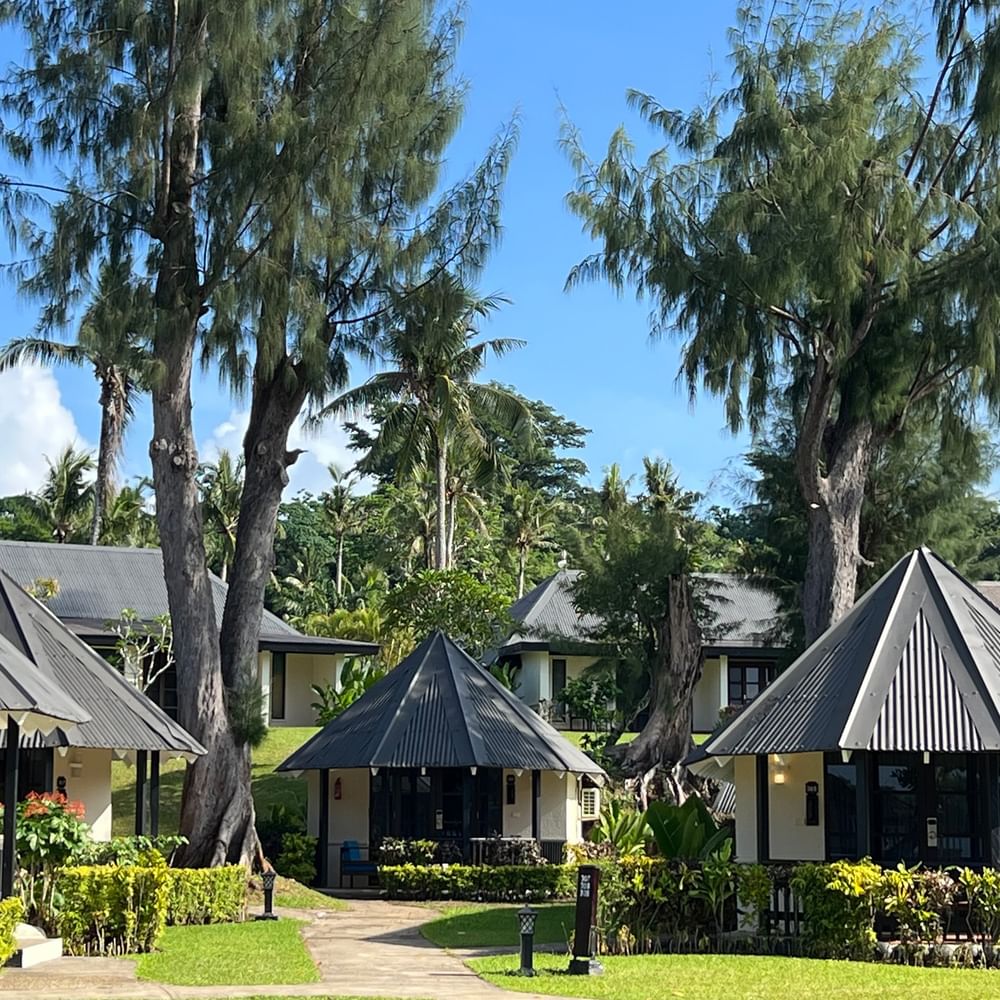Garden Bungalows surrounded by lush greenery and palm trees at Warwick Le Lagon - Vanuatu in Efate.