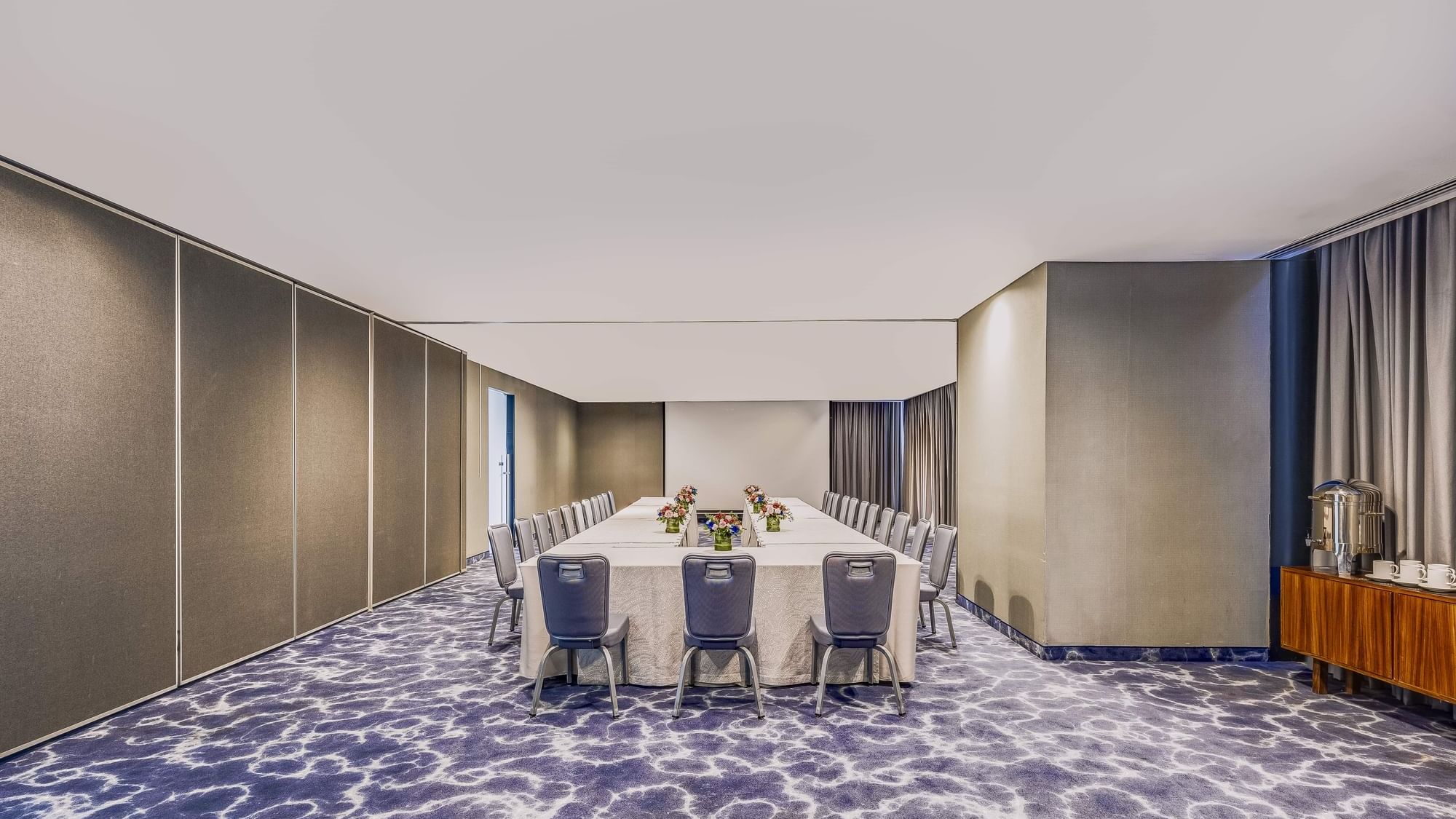 Long dining table set up in meeting room with chairs at Live Aqua Monterrey.