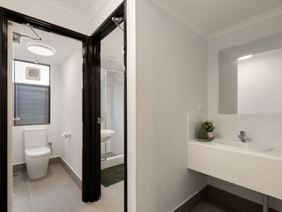 Clean white bathroom with toilet, shower, and sink at UniLodge at Curtin University - Erica Underwood House.