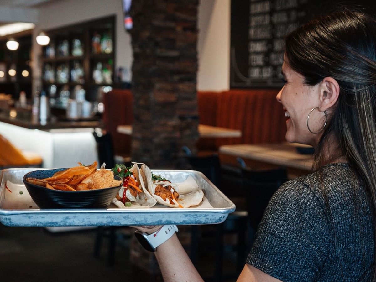 A waitress holding a plate of food
