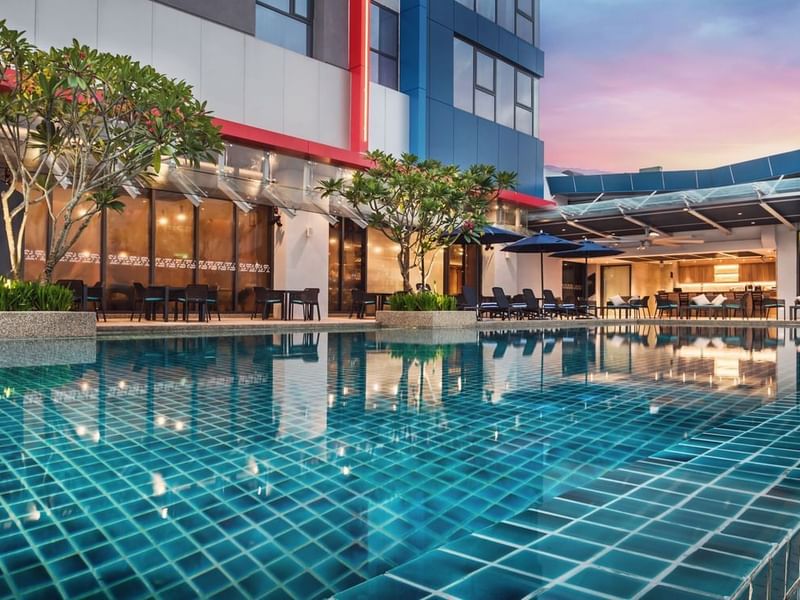 Sun loungers arranged by the pool outdoors in the evening at Sunway Hotel Big Box