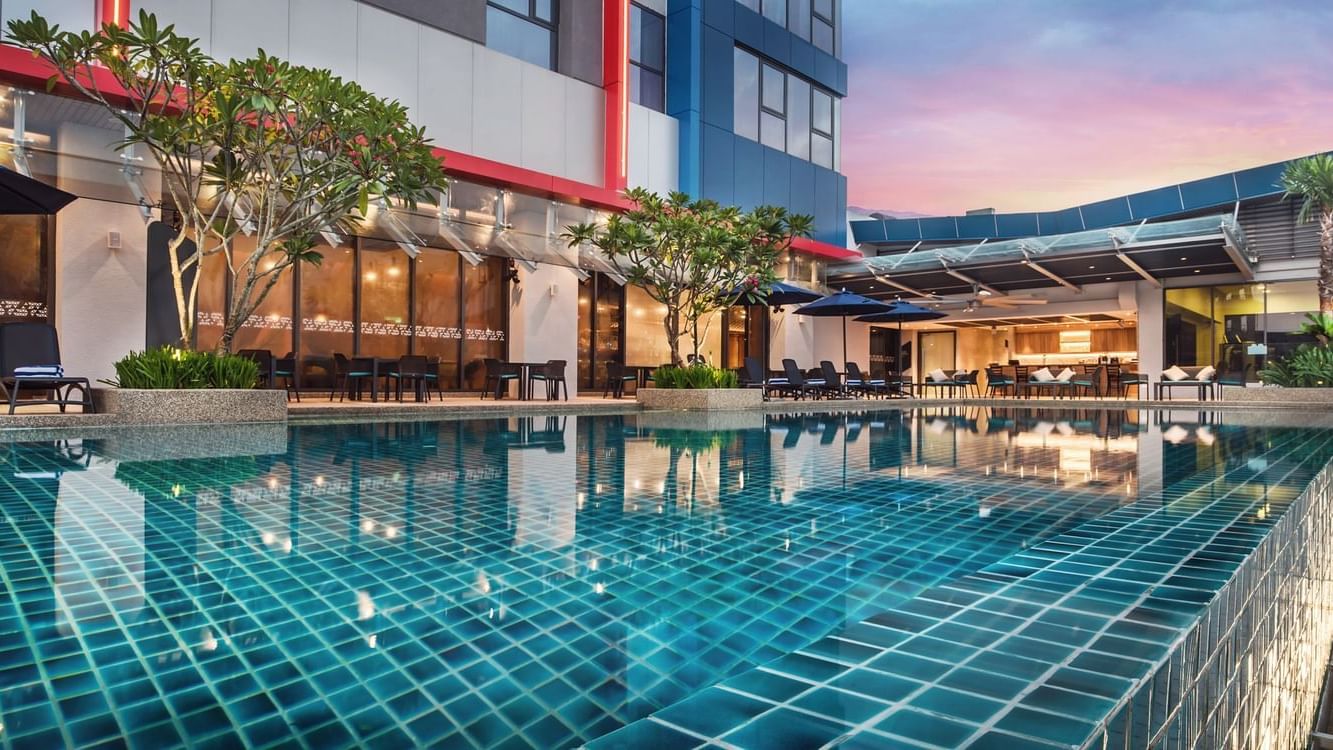 Sun loungers arranged by the pool outdoors in the evening at Sunway Hotel Big Box
