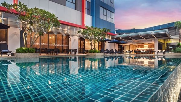 Sun loungers arranged by the pool outdoors in the evening at Sunway Hotel Big Box