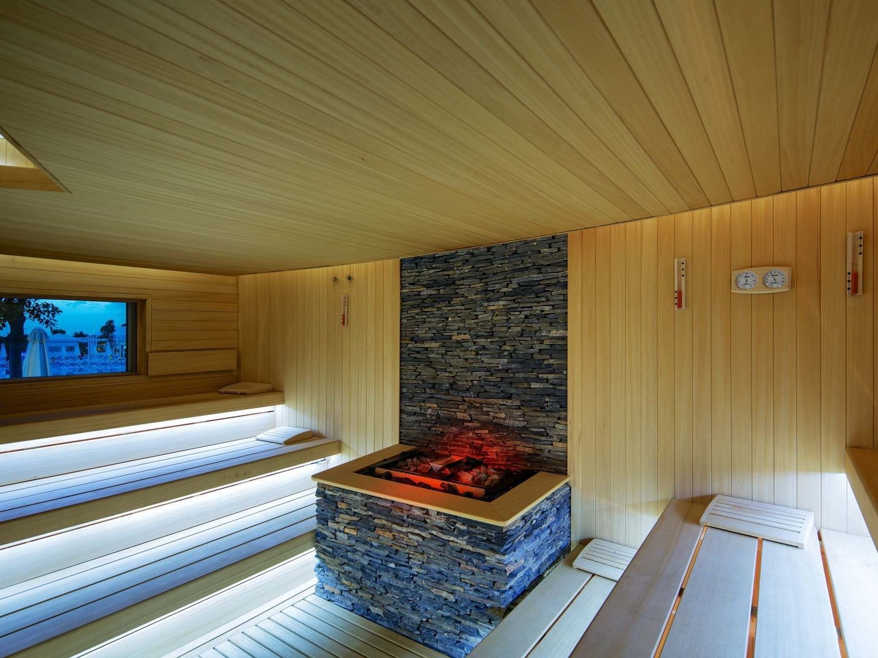 Interior of a wooden sauna with stone heater at Titanic Deluxe Golf Belek