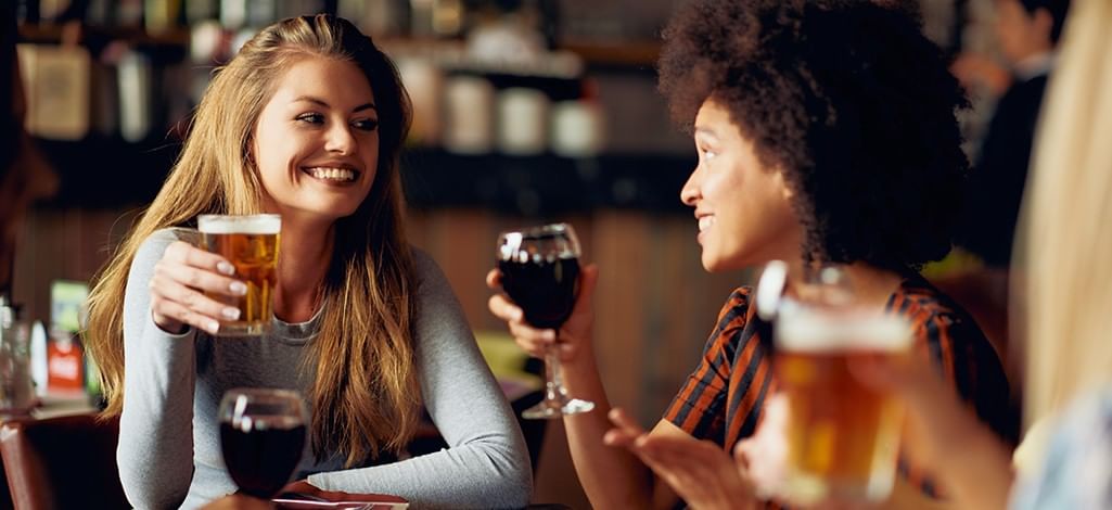 Two women with beer and wine at restaurant