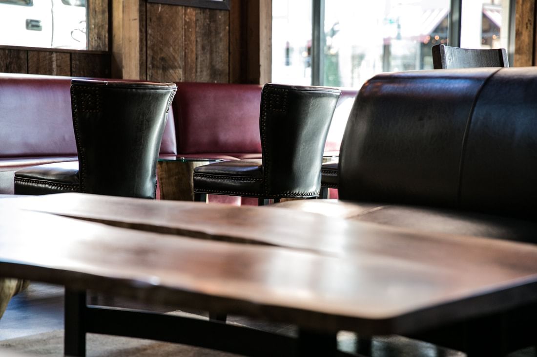 a dining area with a wooden table and leather booths