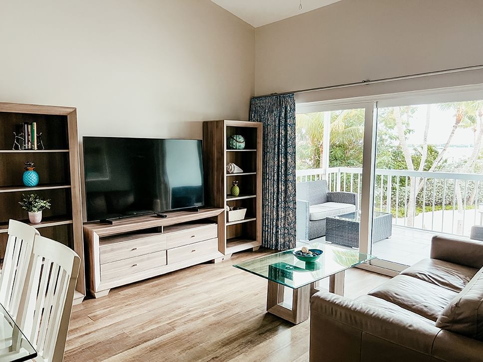 Living area with a large couch and TV in Premier One Bedroom Waterfront Suite at Bayside Inn Key Largo