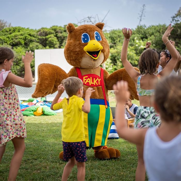 Children interacting with a person in a mascot costume in Falky Land near Falkensteiner Resort Capo Boi