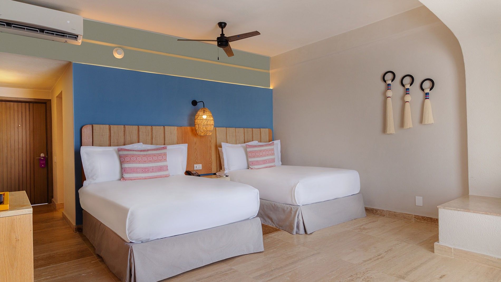 Two Double Camino Real Club Room with two beds, a blue accent wall and woven pendant lights at Camino Real Acapulco Diamante