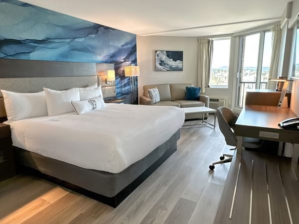 Hotel guestroom with a king bed and a blue wall mural