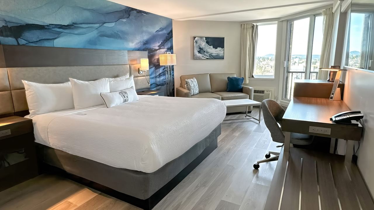 Hotel guestroom with a king bed and a blue wall mural