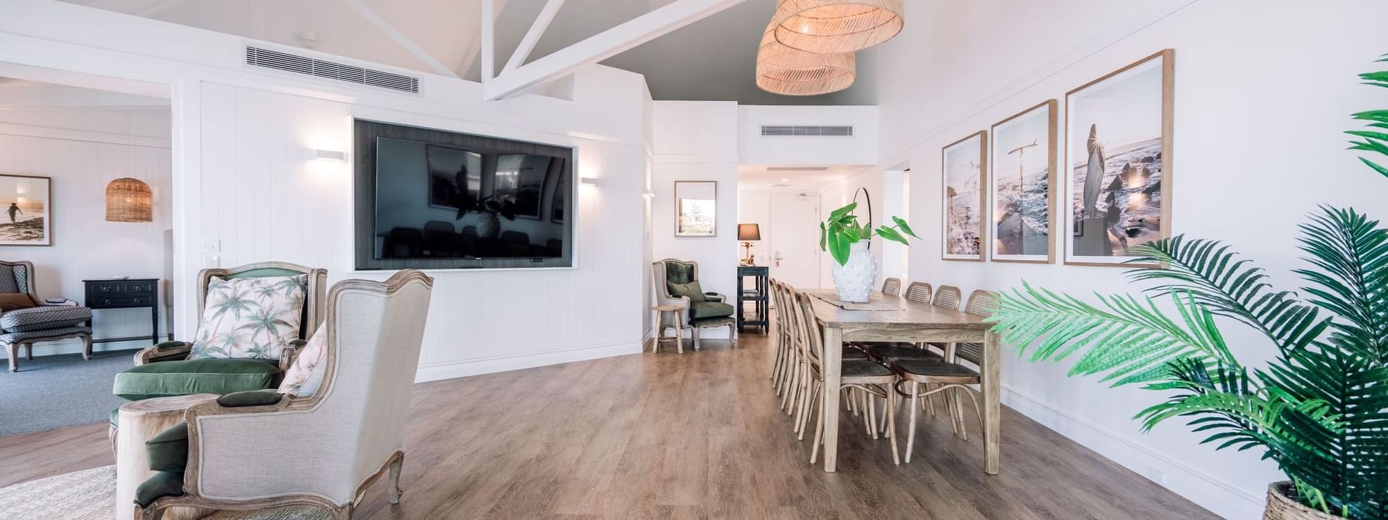 Lounge and dining area with wooden floors in the Grand Overwater Bungalow at Novotel Sunshine Coast Resort