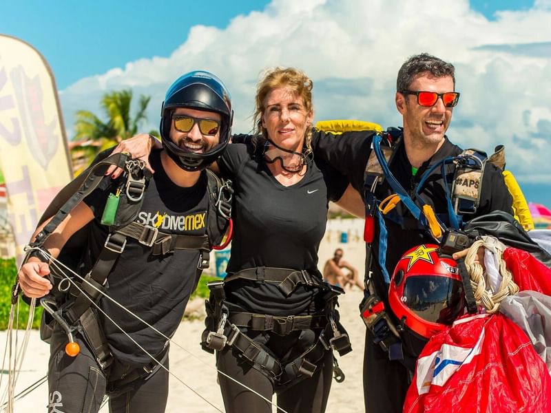 Tres personas con paracaídas en The Reef Coco Beach