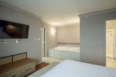 Jacuzzi Suite with bed, TV and Jacuzzi connecting to bathroom at Sandman Hotel & Suites Winnipeg Airport