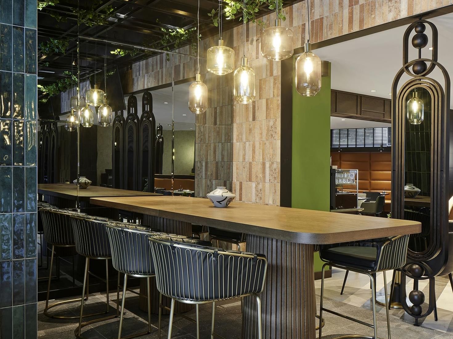 A long bar table with stools in Winter Garden at Titanic Comfort Kurfürstendamm