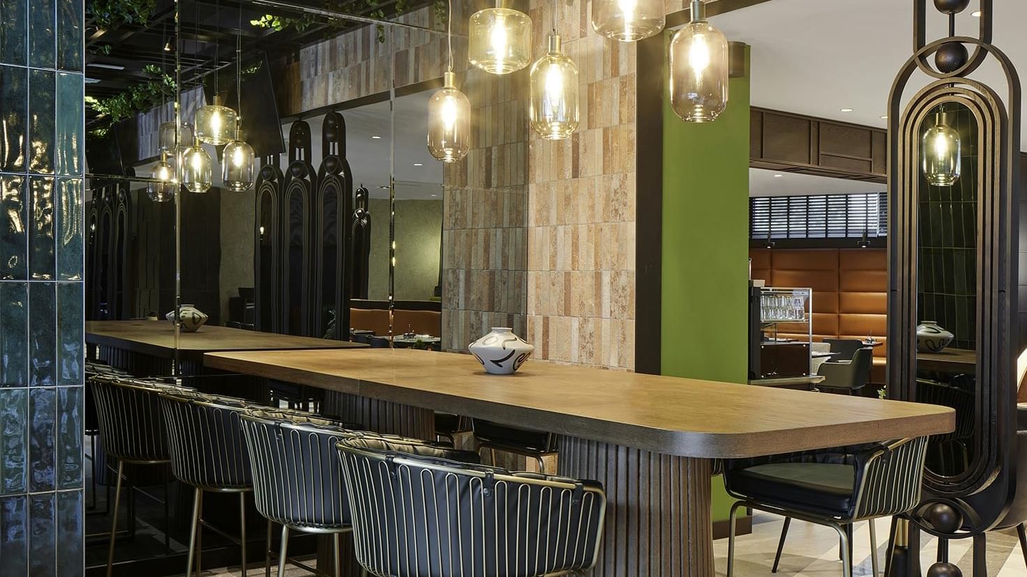 A long bar table with stools in Winter Garden at Titanic Comfort Kurfürstendamm