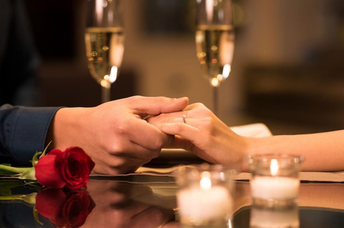 Romantic hand-holding proposal with a diamond ring and roses at Warwick New York